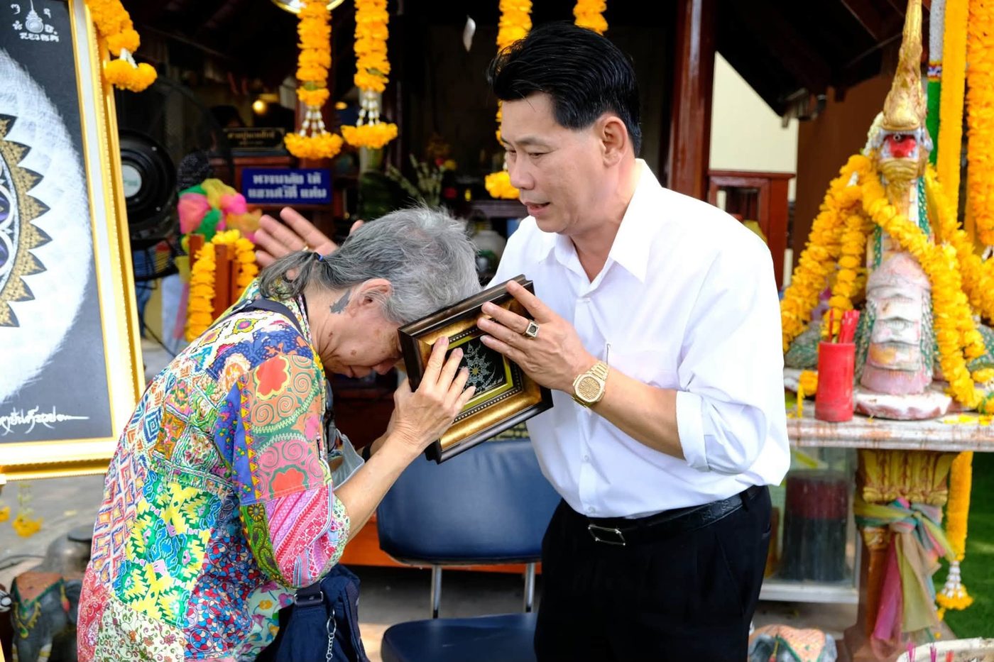 Master Phairot blessing a customer with the Fortune-Opening Yantra